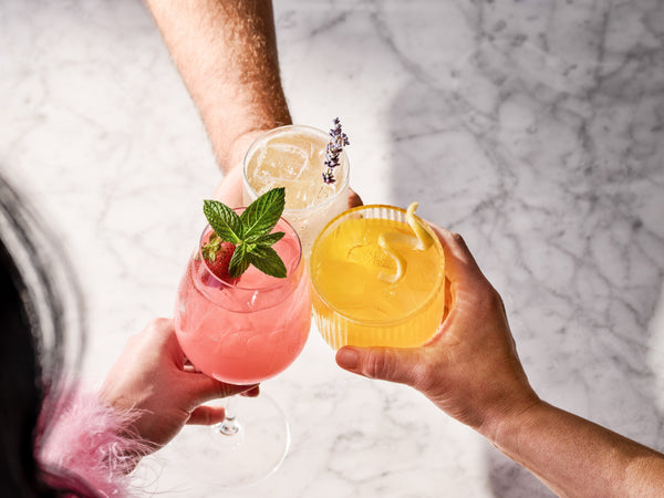 3 drinks being held together in a "cheers" motion in the center of the image