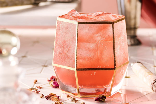 Floral Valentine’s drink with strawberry and rose, served as a light pink sparkling spritz with garnish of dried rose petals.