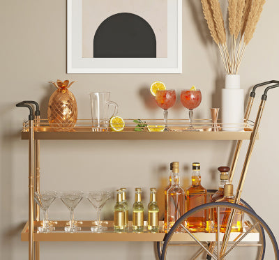 gold beverage cart with drinks and bar tools stacked neatly