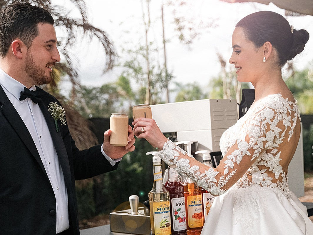 A bride and a groom toasting with two signature drinks made with Monin