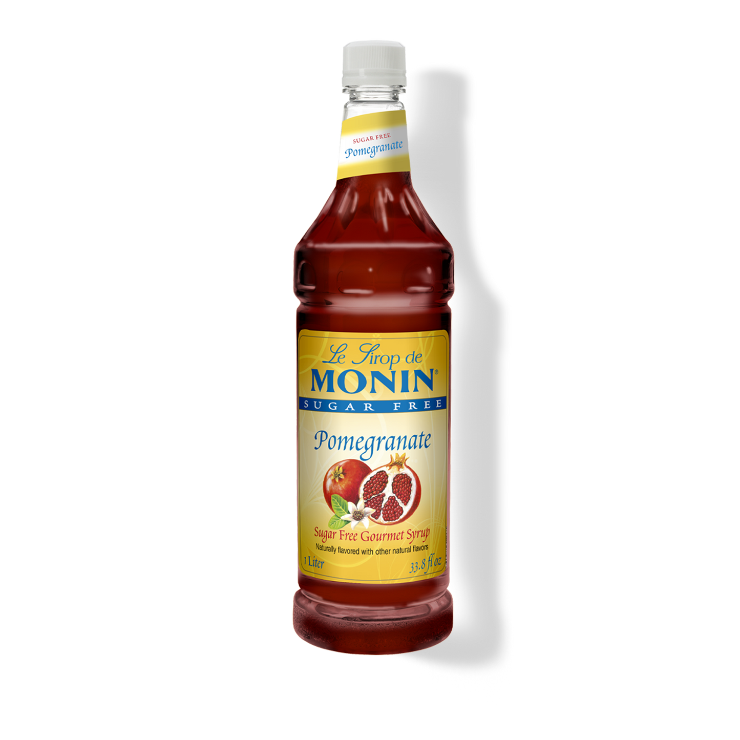 A bottle of Monin sugar-free pomegranate syrup on a white background with a soft shadow. The bottle is filled with deep red syrup and features a yellow label with blue and red text, along with an illustration of a pomegranate.