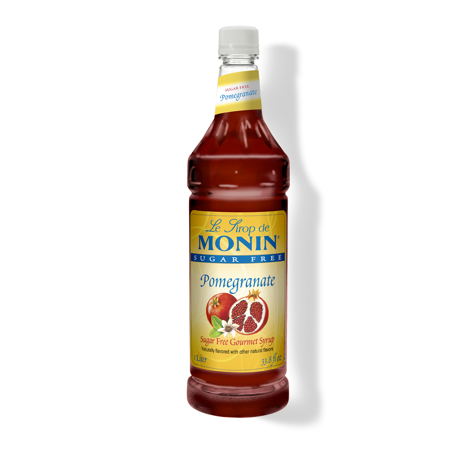 A bottle of Monin sugar-free pomegranate syrup on a white background with a soft shadow. The bottle is filled with deep red syrup and features a yellow label with blue and red text, along with an illustration of a pomegranate.