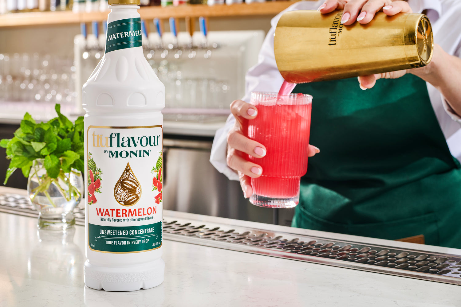 Watermelon flavor bottle with a red drink being poured into a glass