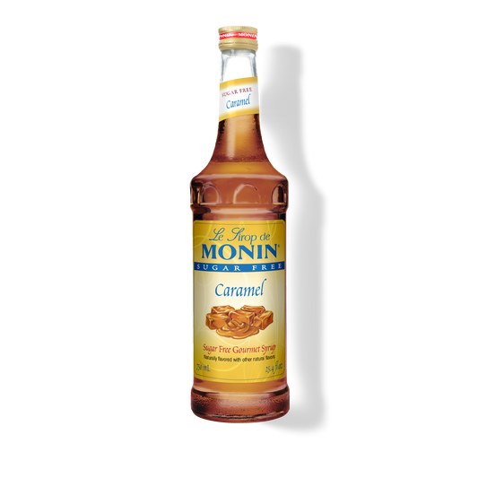 A bottle of Monin Caramel sugar-free syrup on a white background with a soft shadow.