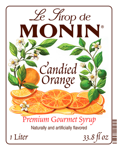 Front label of Le Sirop de Monin Candied Orange syrup, showing orange slices, oranges, limes, and white blossoms on a white background with brown and red text.
