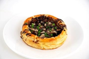 Pastry with spinach and mushroom filling on a white plate