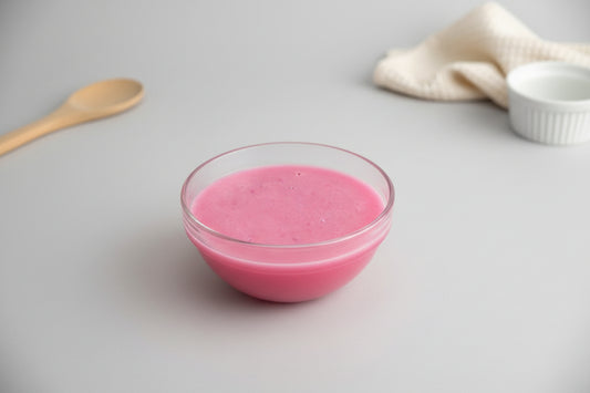 Pink liquid in a clear glass bowl on a white background