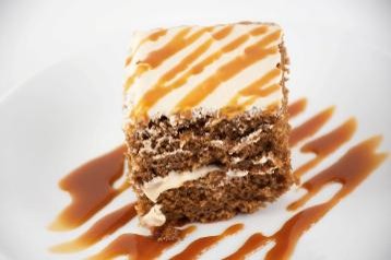 Gingersnap Cake served in a white place and drizzled with caramel sauce