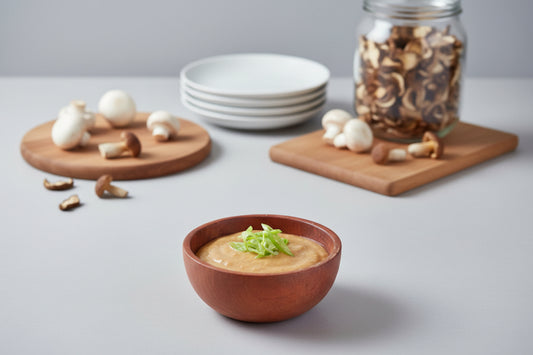 Bowl of mushroom aioli with mushrooms on a table