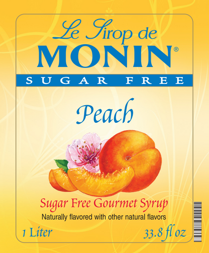 Front of a Le Sirop de Monin Sugar Free Peach syrup bottle label, showing peach slices, a peach, a pink flower, and text indicating 1 Liter / 33.8 fl oz.