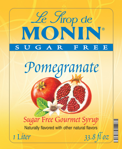 Front of a Le Sirop de MONIN Sugar Free Pomegranate syrup package, showing a yellow label with a pomegranate and white flower illustration, plus text indicating 1 Liter / 33.8 fl oz.